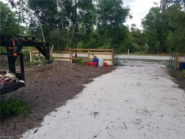 View of property's community with view of wooded area and a gate