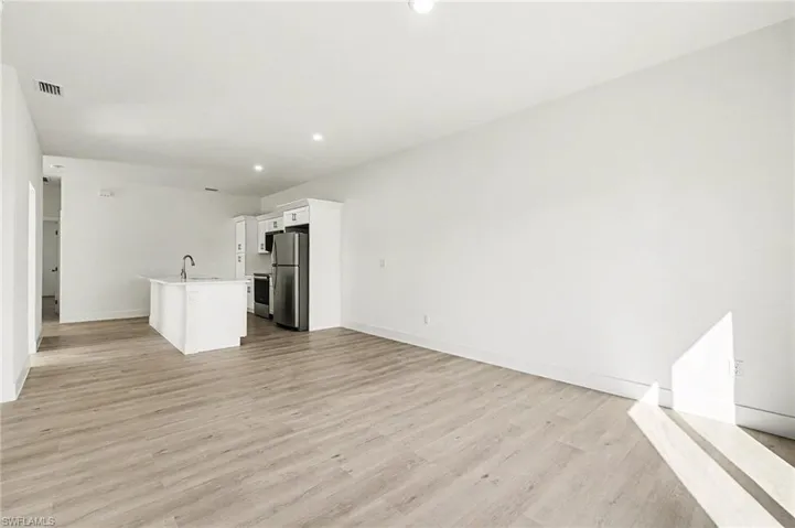 Unfurnished living room with light wood finished floors and recessed lighting