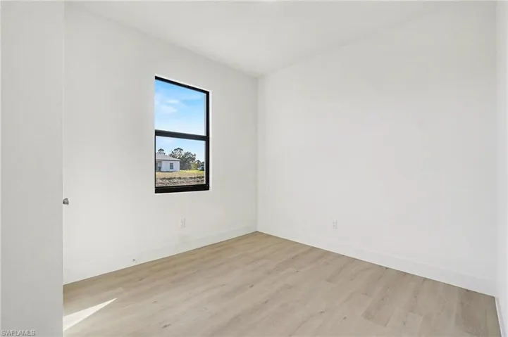 Spare room with light wood-style floors and baseboards
