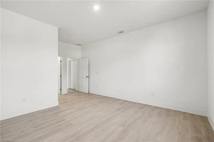 Unfurnished room with light wood finished floors and baseboards