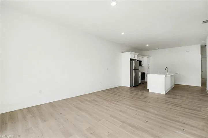 Unfurnished living room with light wood-type flooring and recessed lighting