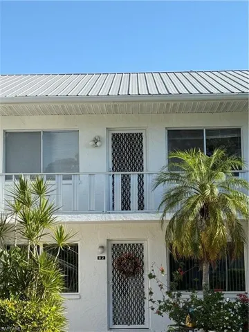 Property entrance featuring a balcony and stucco siding
