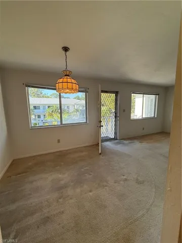 Unfurnished dining area with baseboards and carpet flooring