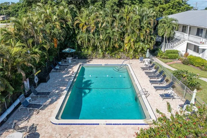 Community pool featuring fence and a patio area