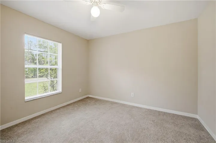 Carpeted room with a ceiling fan, a window with blinds, and neutral wall paint