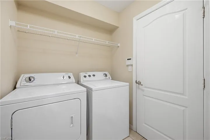 Utility area featuring a white wire shelf, neutral wall tones, and a paneled interior door with brushed nickel hardware