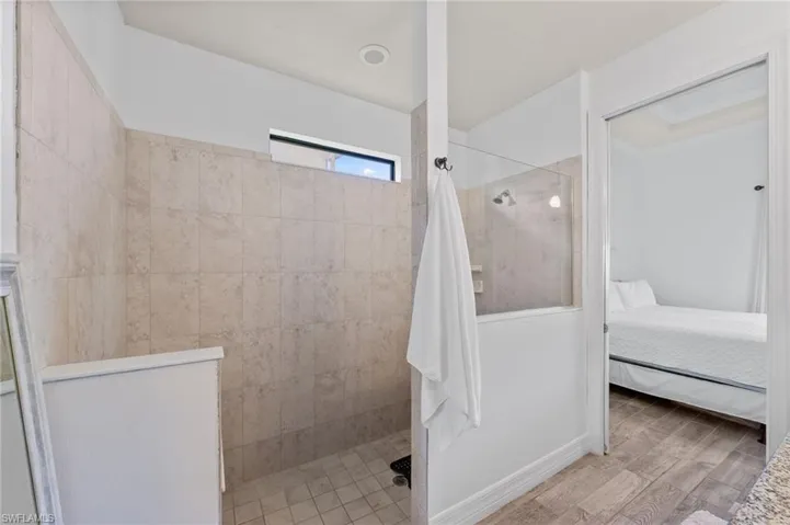 Ensuite bathroom featuring walk in shower and light wood-type flooring