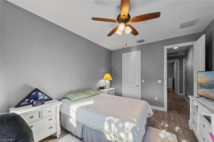 Bedroom with light wood-style flooring, ceiling fan, and a closet