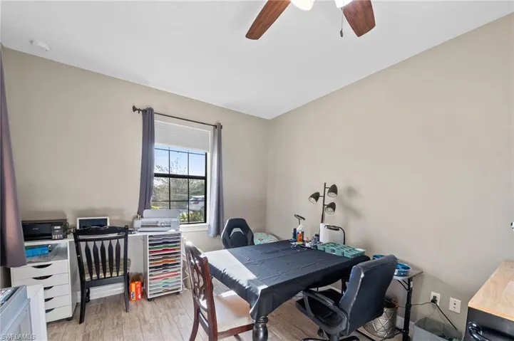Office space with light wood-style flooring and ceiling fan