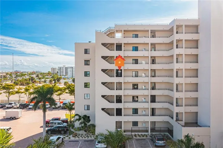 View of apartment building / complex featuring uncovered parking and a view of city