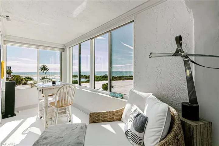 Sunroom with a textured wall and a water view