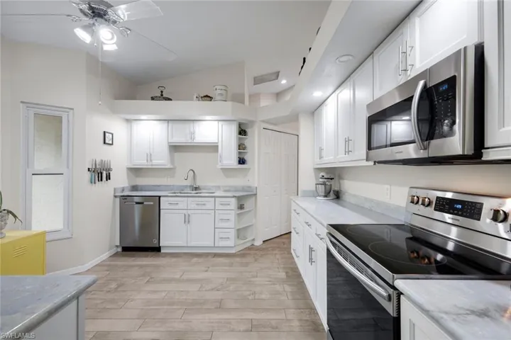 Kitchen features shaker cabinets and stainless appliances.