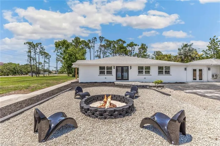 Side of house featuring a fire pit and french doors