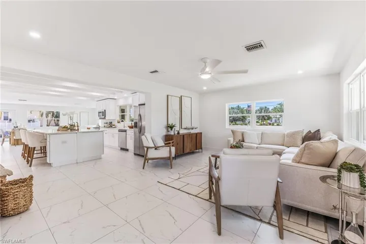 Living room with ceiling fan and light tile flooring