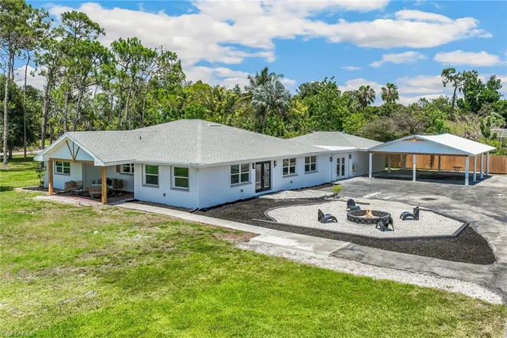 Side of house featuring a pole barn, fire pit and a yard