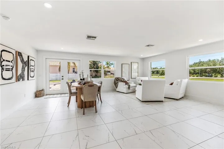 Living area featuring ceiling fan, natural lighting, light tile