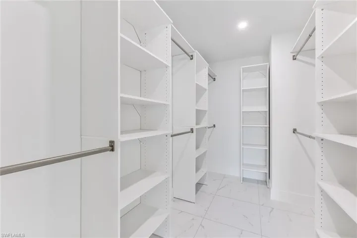 Owners Suite walk in closet with light tile floors