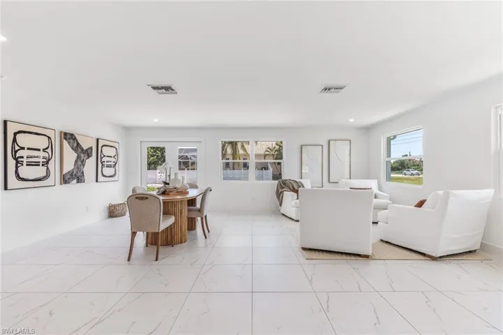 Tiled living room featuring a healthy amount of sunlight and french doors