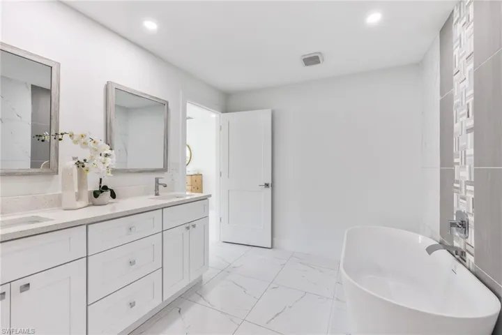 Owners suite bathroom featuring tile flooring and double sink vanity