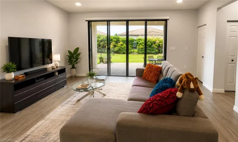 Spacious living area featuring wood-finish flooring and light grey walls