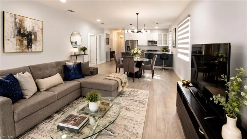 Open-concept living space featuring wood-finish flooring, recessed lighting, and light gray wall tones