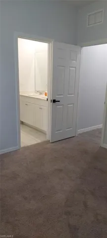 Spare room featuring light colored carpet and baseboards