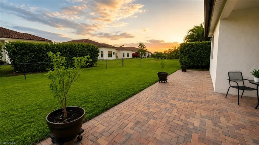 Expansive paver patio extending to a lush green lawn