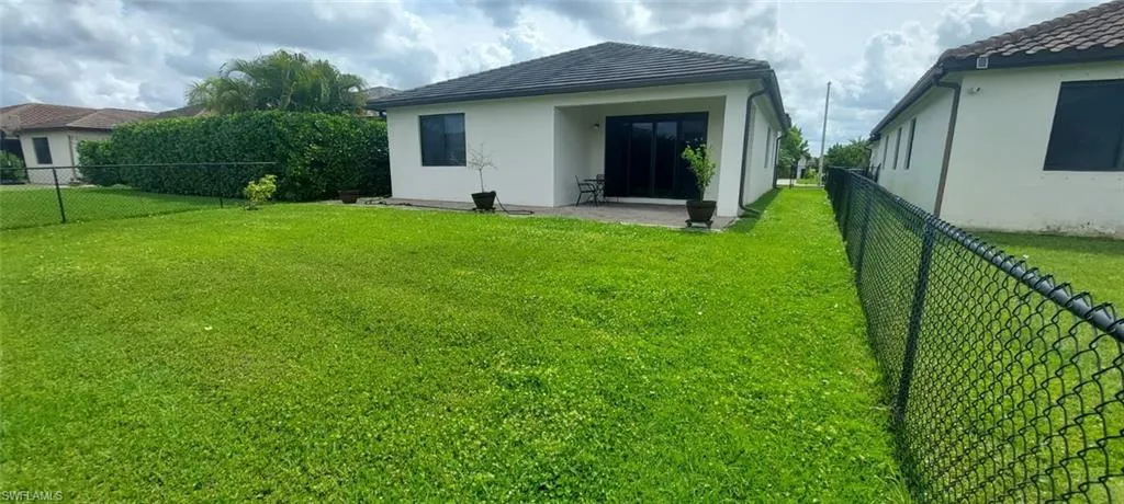 Rear view of property with a fenced backyard, a patio, and stucco siding