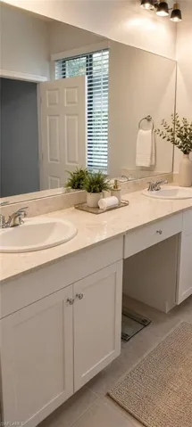 Dual vanity featuring white shaker-style cabinetry, undermount sinks, and a light-toned countertop