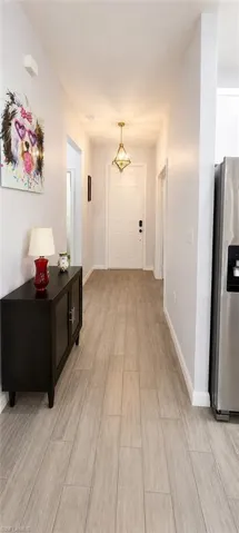 Entryway featuring wood-finish tile flooring, a built-in ceiling light fixture, and a solid entry door with dark hardware