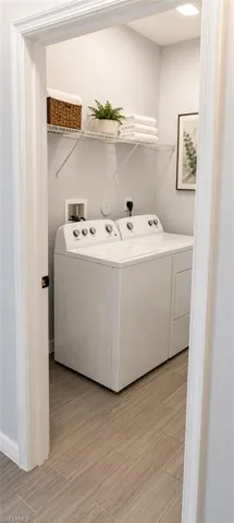 Dedicated laundry area featuring a tile floor, white walls, and built-in wire shelving