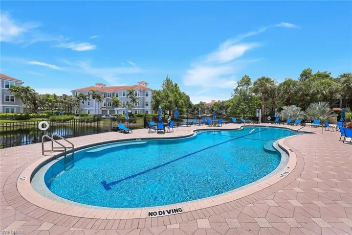 Expansive outdoor pool with a paved deck and integrated lane lines