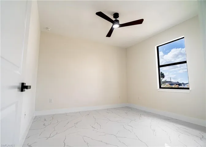 Spare room featuring light marble finish flooring and ceiling fan