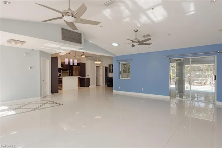 Unfurnished living room with lofted ceiling and light tile patterned flooring