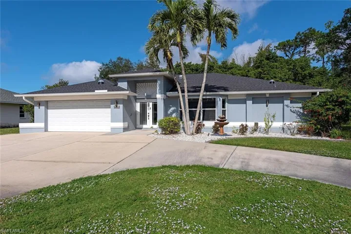 View of front of property featuring a garage and a front lawn