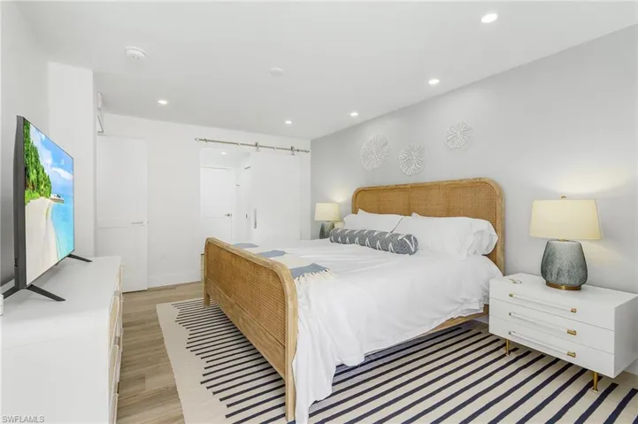 Bedroom featuring a barn door and light wood-type flooring
