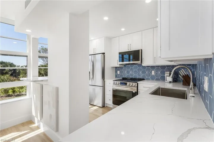 Kitchen featuring a wealth of natural light, appliances with stainless steel finishes, sink, and tasteful backsplash