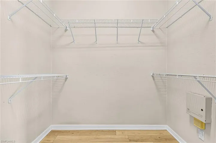 Walk-in closet featuring wire shelving and hanging rods, light wood-finish flooring, and light-toned wall finishes
