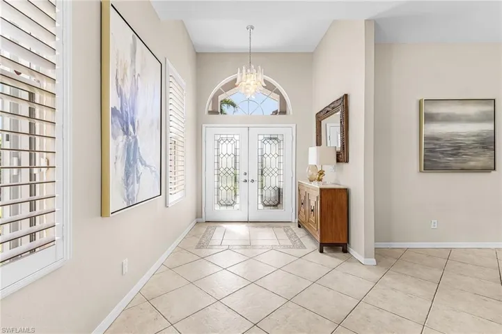 Double entry doors with decorative glass panels and an arched transom