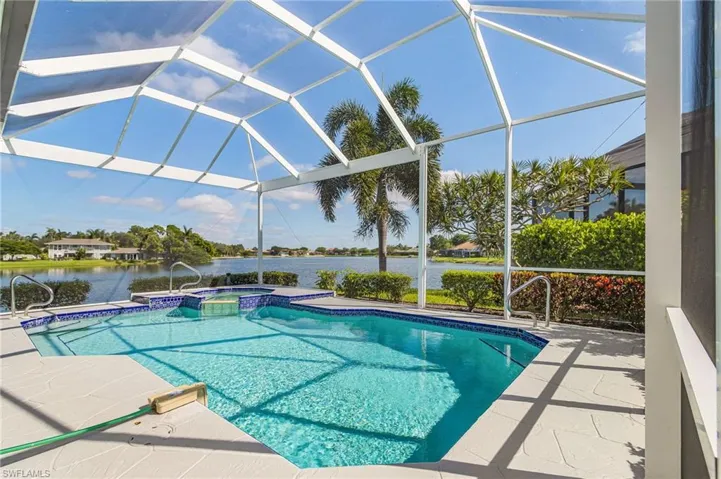 Screened enclosure featuring a swimming pool, integrated spa, and expansive water frontage