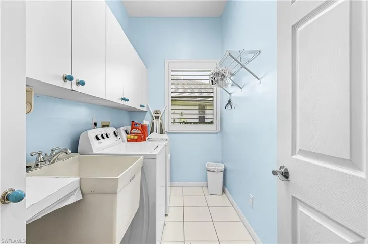 Laundry room featuring white cabinetry, a utility sink, and tile flooring