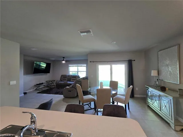 Dining area with light tile patterned floors and a ceiling fan