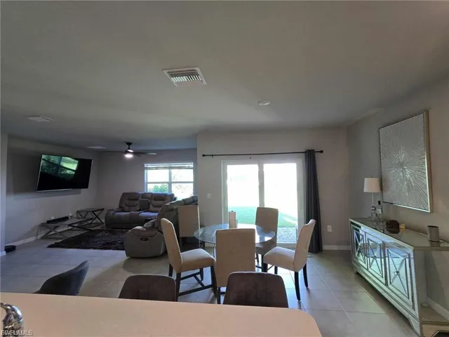 Dining area featuring light tile patterned flooring and a ceiling fan