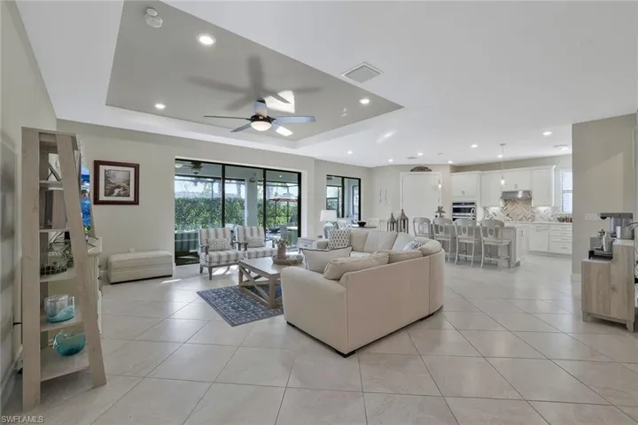 Tiled living room with a raised ceiling and ceiling fan