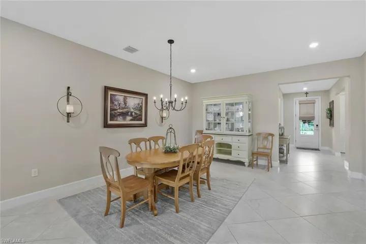 Dining area with light tile patterned floors and a notable chandelier