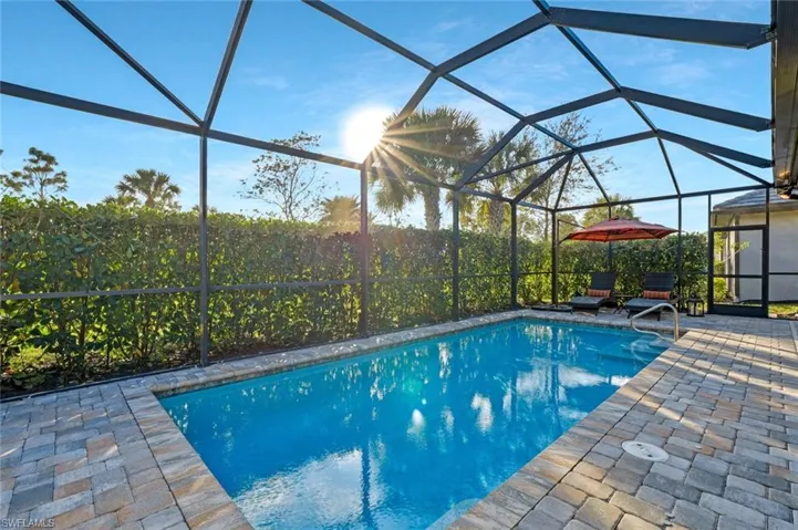 View of pool featuring a patio and glass enclosure