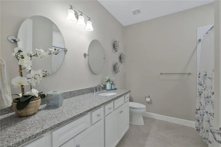 Bathroom featuring vanity, tile patterned floors, and toilet