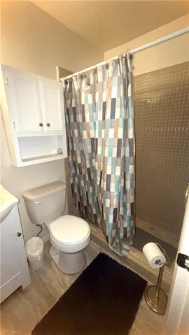 Full bath featuring a stall shower, vanity, and light wood-style floors