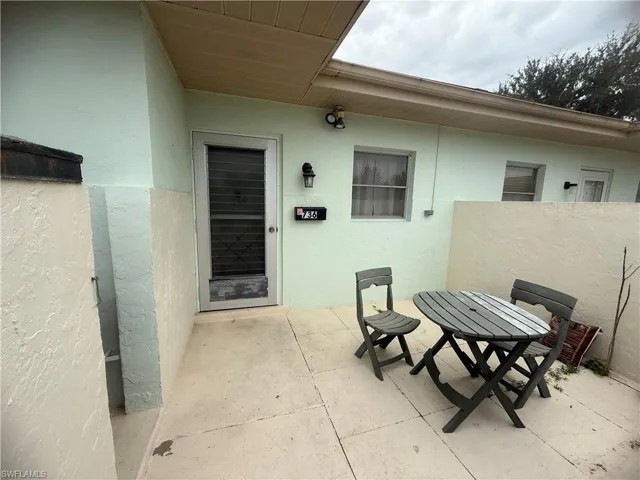 Doorway to property with stucco siding, a patio area, and outdoor dining area