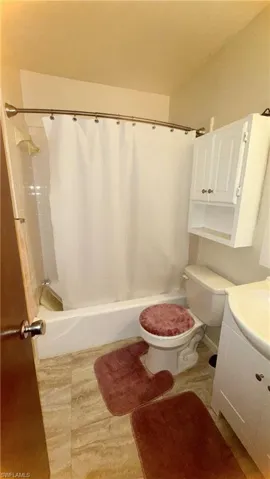 Bathroom featuring shower / bath combo with shower curtain and vanity